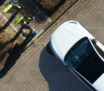 Vue d'en haut d'une voiture électrique raccordée à une borne de charge